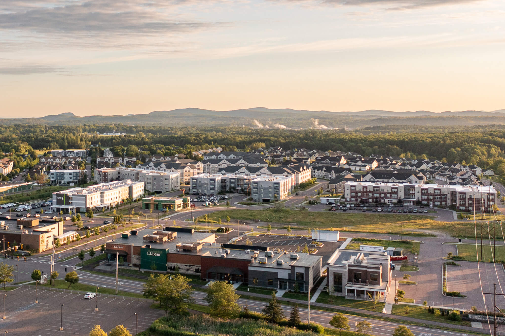 A aerial shot of finney crossing apartments with the mountains in the background during sunset